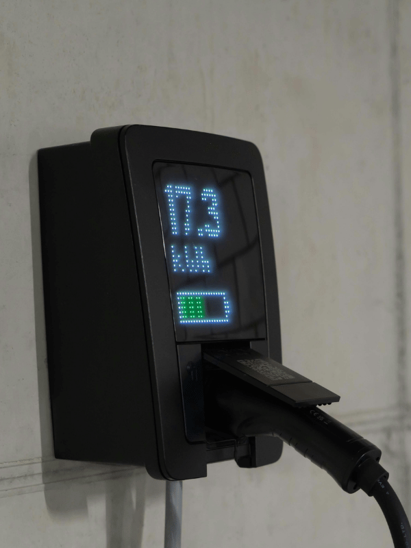 Close-up of a home EV charger plugged into an electric vehicle
